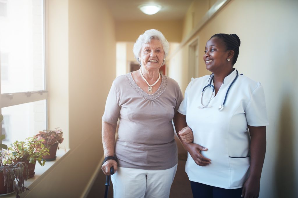 Happy healthcare worker and senior woman together at nursing home in Laguna Hills, California.